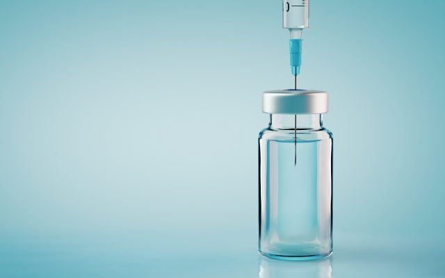 Bottle of Vaccine With Syringe In the Top Representing a Covid 19 Vaccine