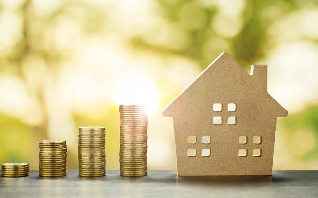 House Model and Golden Coins Stacks with blur Background.Savings Plans for Housing,Finance and Banking about House concept.