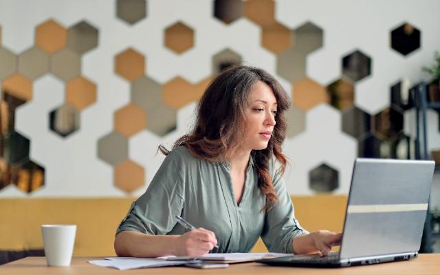 How to protect yourself from cybersquatting - image of a woman using a laptop in a modern office.